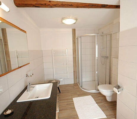 Badezimmer mit Doppelwaschbecken, WC und Dusche