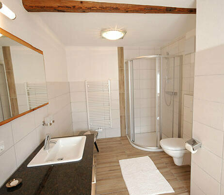 Badezimmer mit Doppelwaschbecken, WC und Dusche